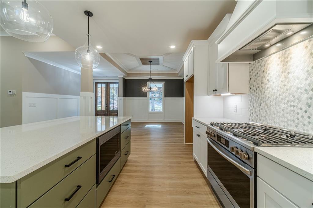 327 Pine Circle Monroe, GA 30655 - Photo 13 of 69 a kitchen with stainless steel appliances granite countertop a stove and a wooden floors