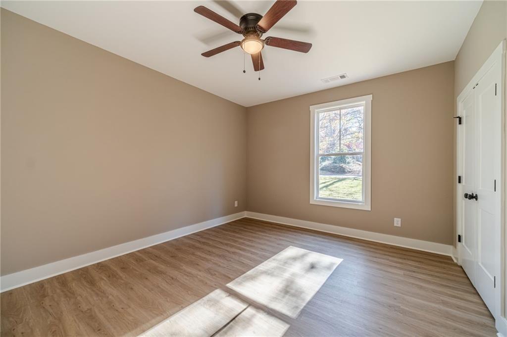 327 Pine Circle Monroe, GA 30655 - Photo 27 of 69 wooden floor in an empty room with a window