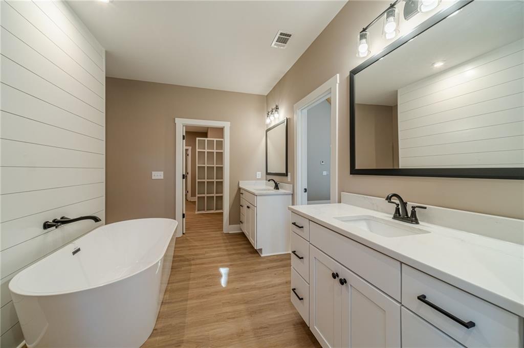 327 Pine Circle Monroe, GA 30655 - Photo 38 of 69 a spacious bathroom with a double vanity sink a mirror and a bathtub