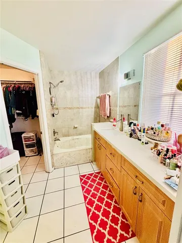 a spacious bathroom with a double vanity sink mirror and bathtub