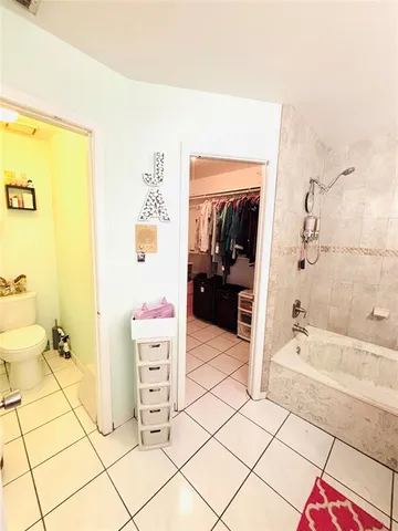 a spacious bathroom with a tub shower and a sink