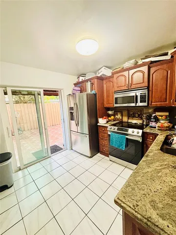 a kitchen with stainless steel appliances granite countertop a refrigerator and a stove top oven