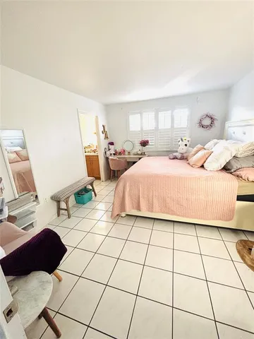 a bedroom with a bed a mirror and lamp on desk