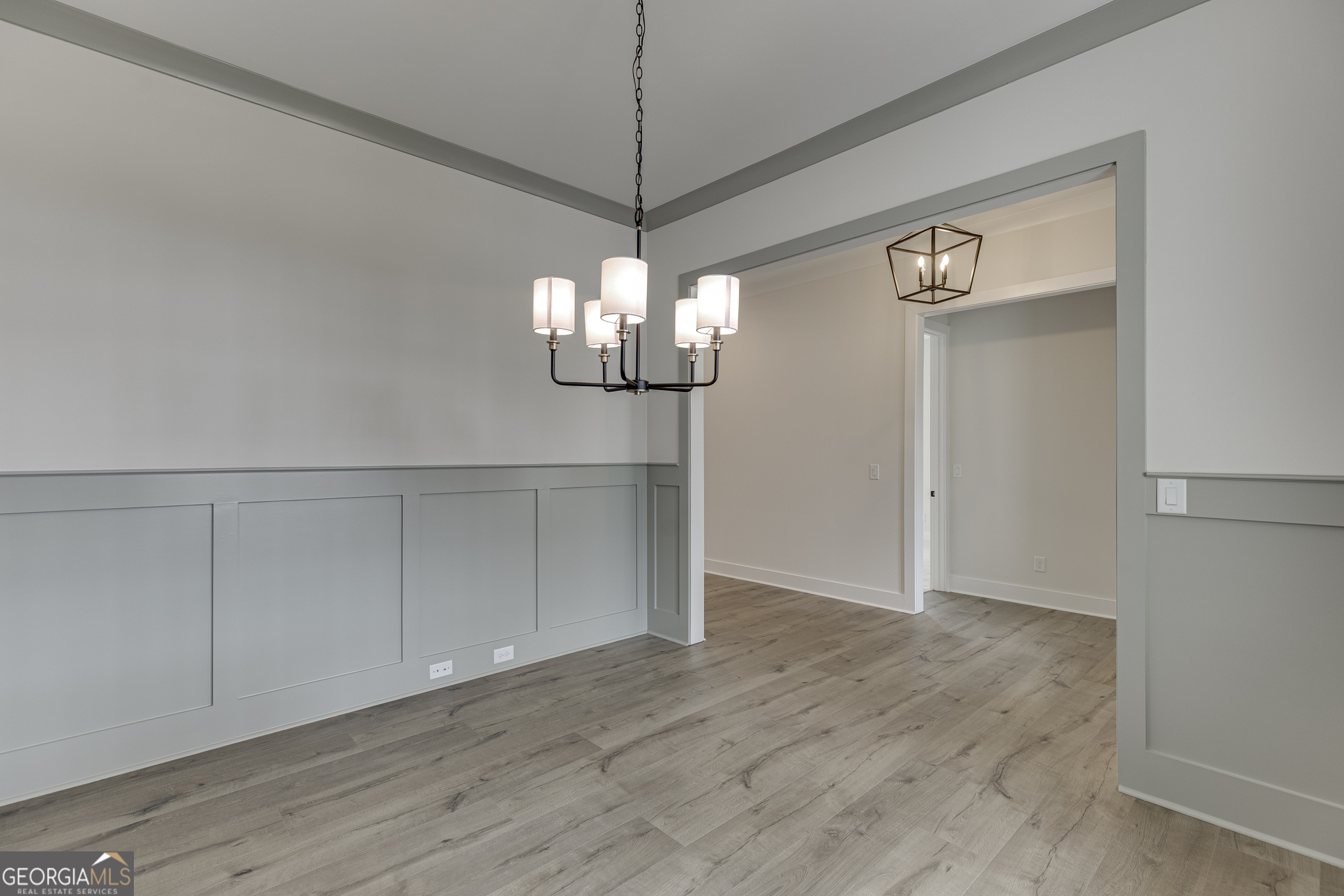 5410 Settingdown Road Cumming, GA 30028 - Photo 14 of 86 a view of an empty room with wooden floor and chandelier