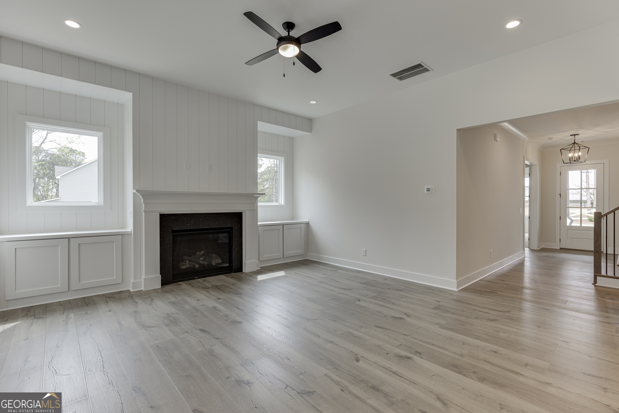 5410 Settingdown Road Cumming, GA 30028 - Photo 32 of 86 an empty room with wooden floor a fireplace and windows