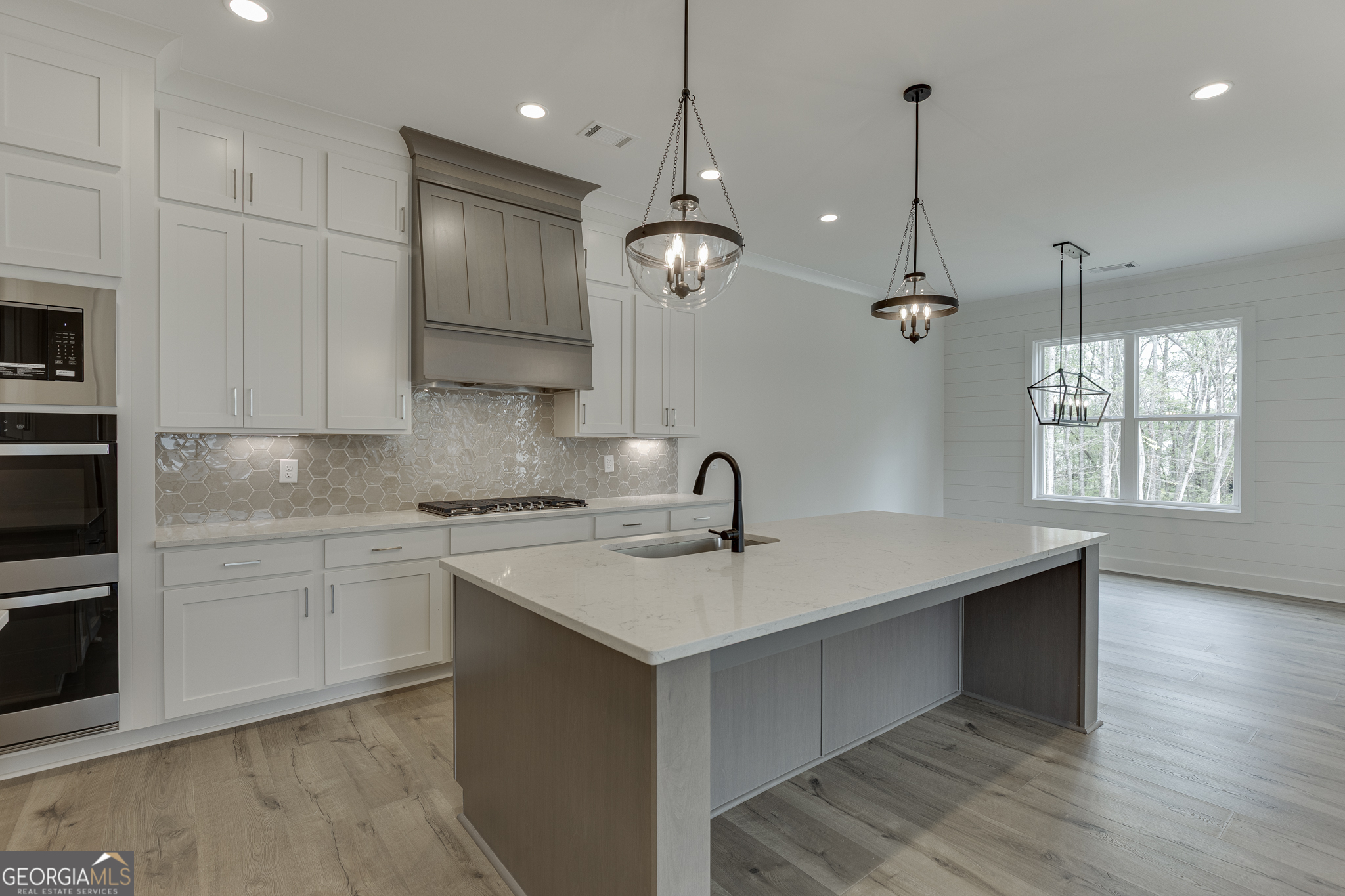 5410 Settingdown Road Cumming, GA 30028 - Photo 40 of 86 a kitchen with a sink chandelier stainless steel appliances and cabinets