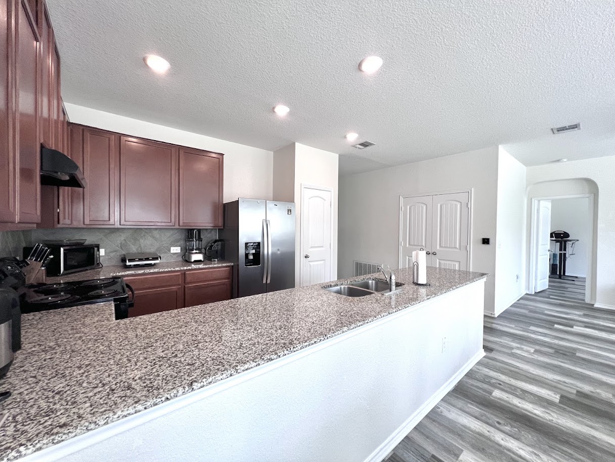 7900 Crystalbrook West Austin, TX 78724 - Photo 19 of 27 a large kitchen with granite countertop a large counter top stainless steel appliances and cabinets