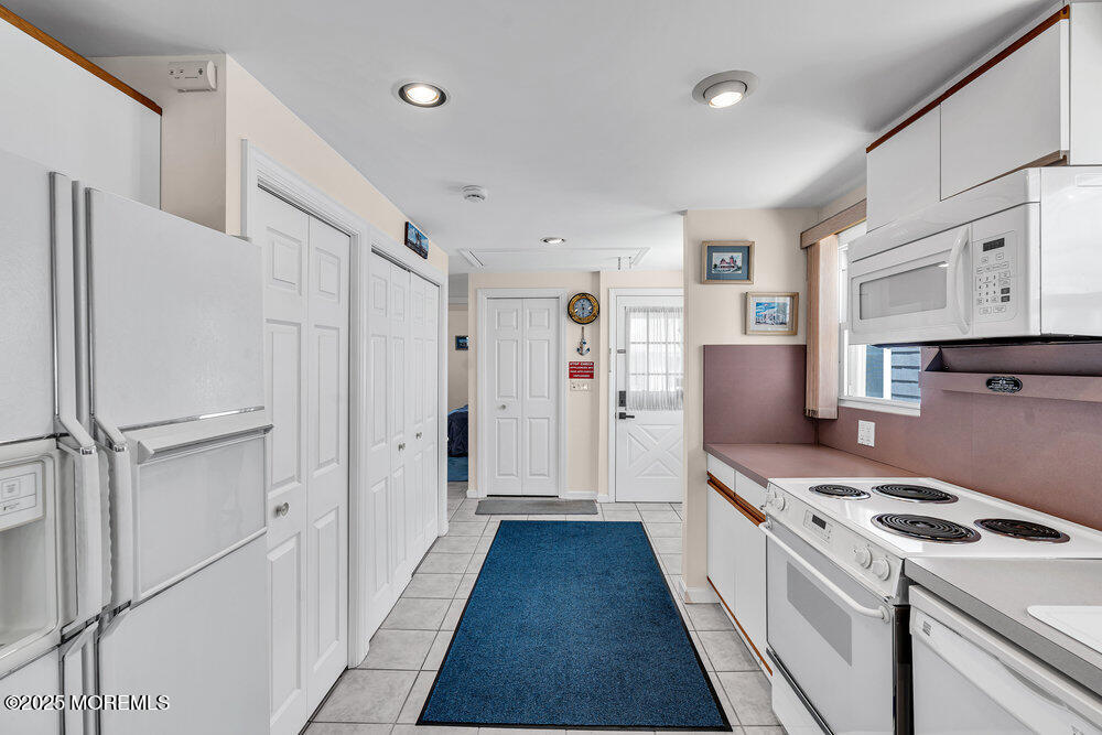 115 Beach Front Manasquan, NJ 08736 - Photo 14 of 32 a kitchen with stainless steel appliances a refrigerator sink and white cabinets