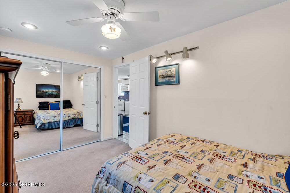 115 Beach Front Manasquan, NJ 08736 - Photo 24 of 32 a bedroom with a bed and a chandelier