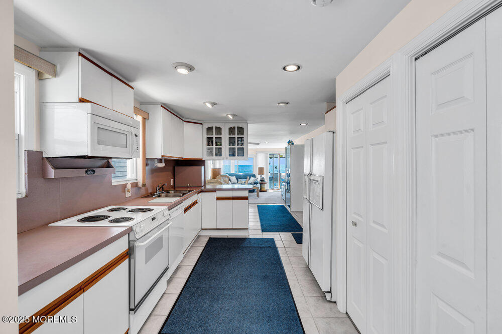 115 Beach Front Manasquan, NJ 08736 - Photo 6 of 32 a kitchen with white cabinets and appliances