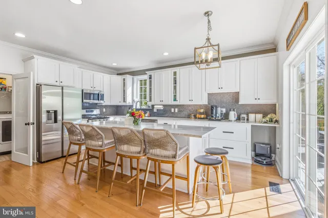 a kitchen with stainless steel appliances granite countertop a stove a refrigerator a sink dishwasher with a dining table and chairs