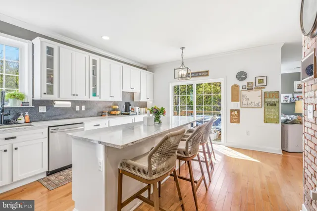 a kitchen with stainless steel appliances granite countertop a stove top oven a sink a dining table and chairs