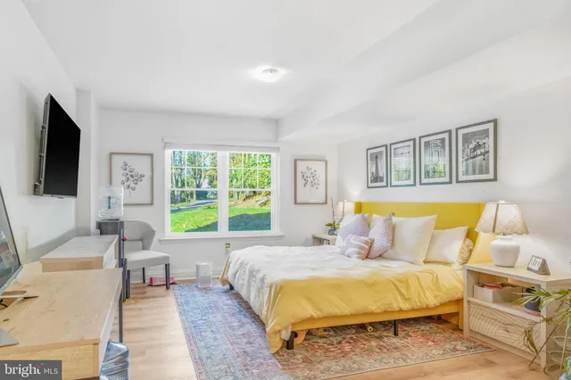 a living room with toilet a flat screen tv and a window
