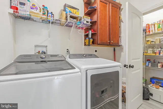 a kitchen with stainless steel appliances a dining table chairs refrigerator and cabinets