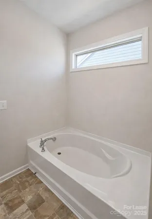 a white bath tub sitting next to a window