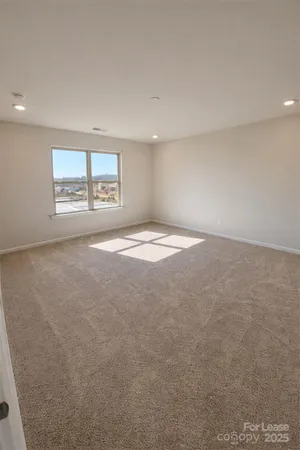 an empty room with windows and ceiling fan