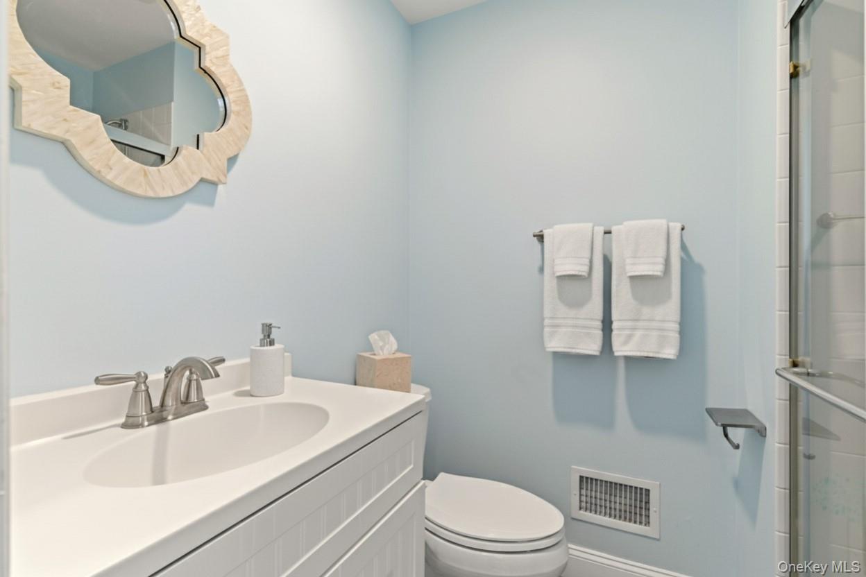 9 Mariners Court Centerport, NY 11721 - Photo 24 of 40 a bathroom with a sink a toilet and a mirror