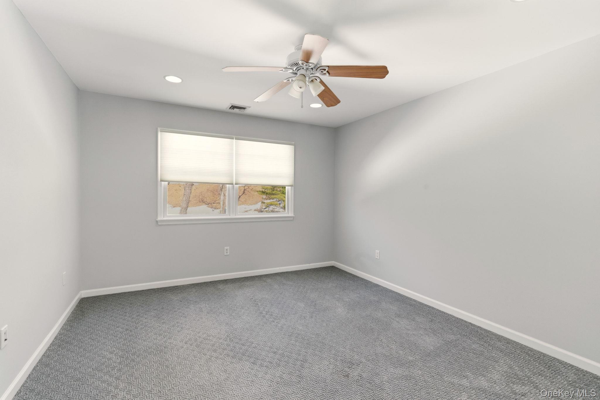 9 Mariners Court Centerport, NY 11721 - Photo 26 of 40 an empty room with a window and a ceiling fan