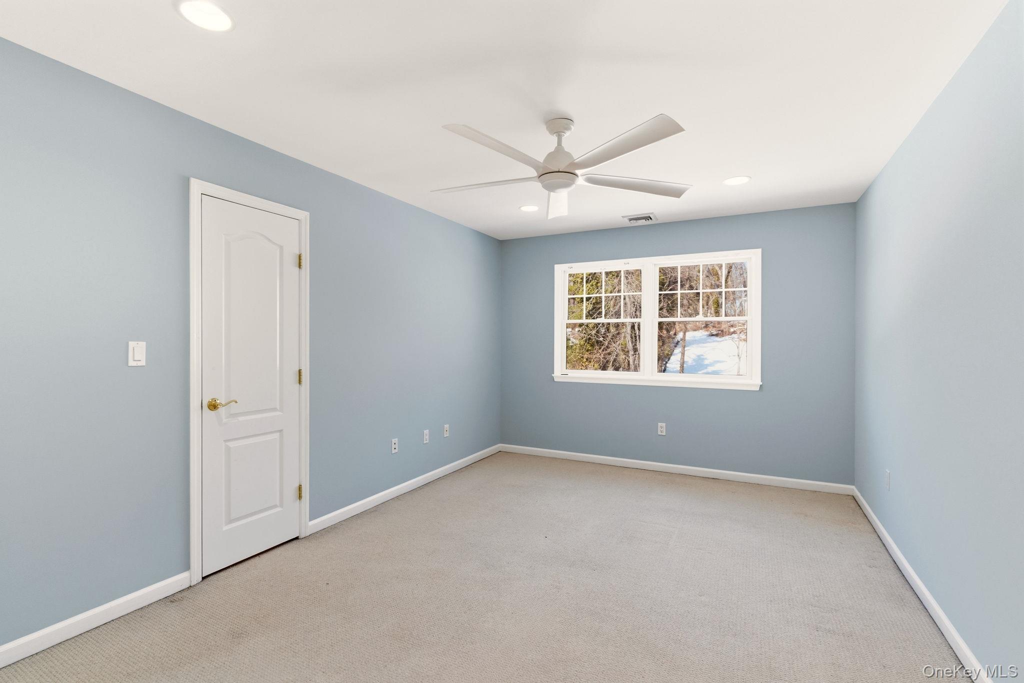 9 Mariners Court Centerport, NY 11721 - Photo 30 of 40 an empty room with a window and a ceiling fan