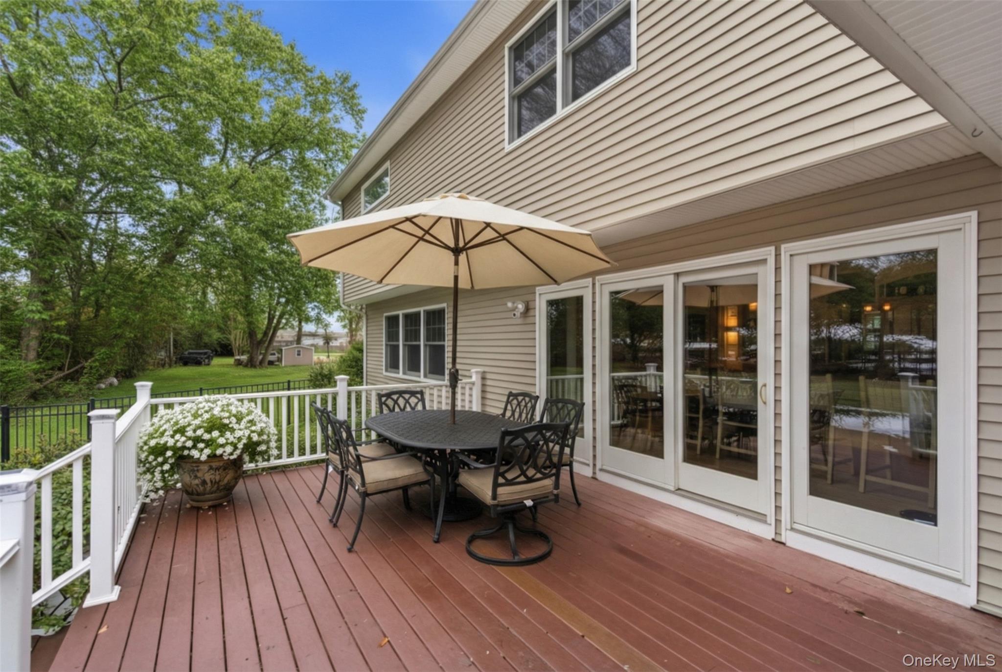 9 Mariners Court Centerport, NY 11721 - Photo 35 of 40 a view of a roof deck with table and chairs under an umbrella