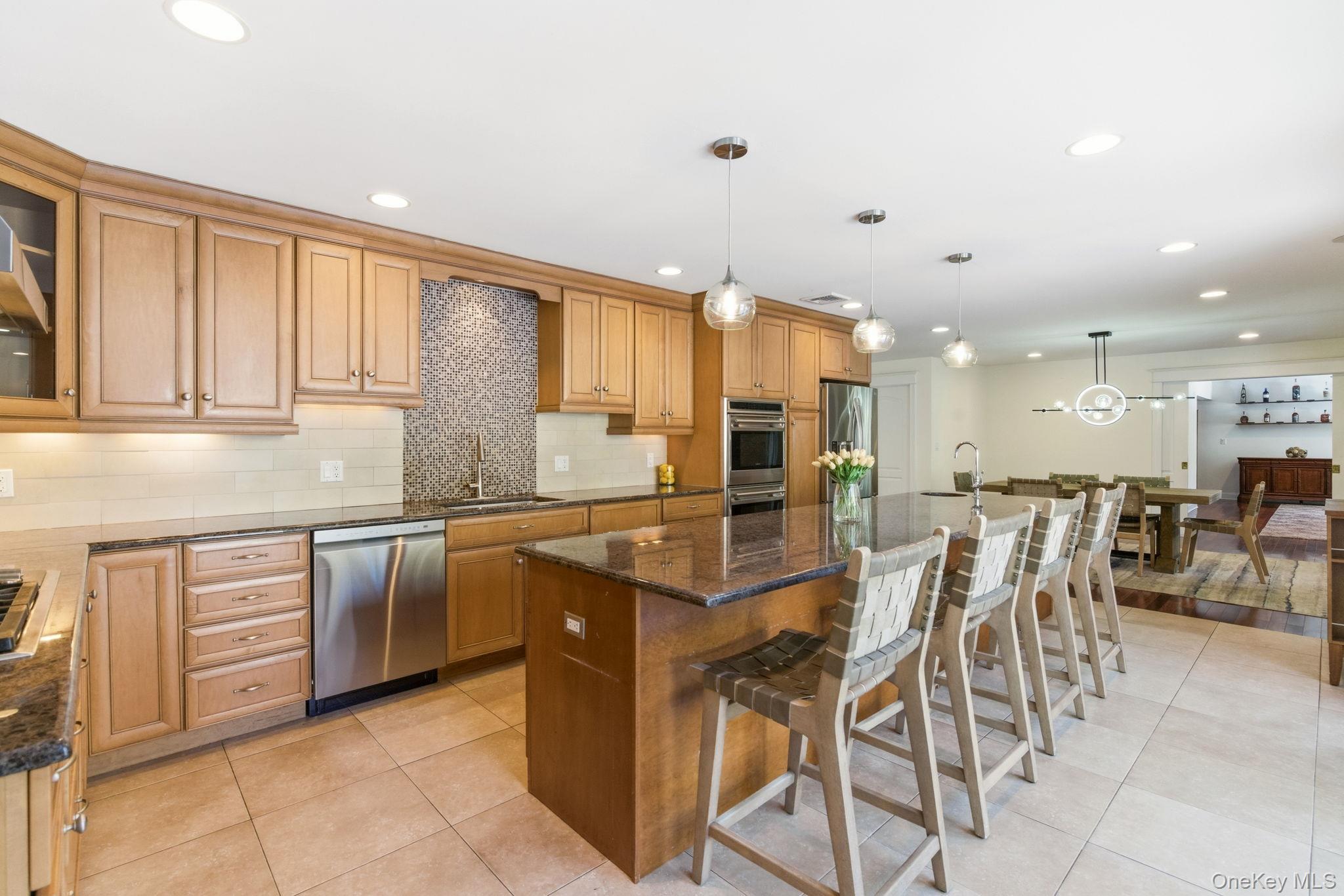 9 Mariners Court Centerport, NY 11721 - Photo 8 of 40 a kitchen with stainless steel appliances kitchen island granite countertop a table and chairs in it