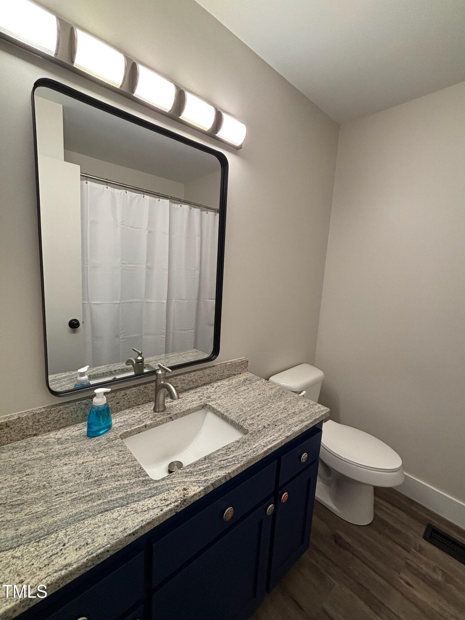 2413 Trawick Road Raleigh, NC 27604 - Photo 16 of 43 a bathroom with a granite countertop sink and a mirror