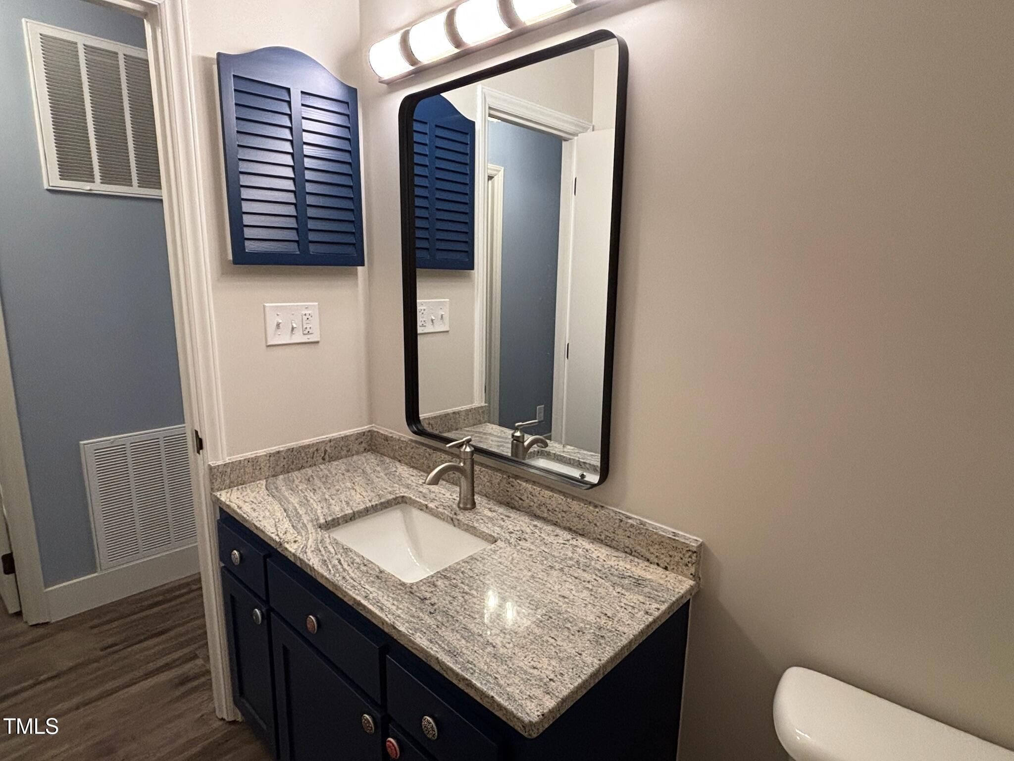 2413 Trawick Road Raleigh, NC 27604 - Photo 17 of 43 a bathroom with a granite countertop sink and a mirror