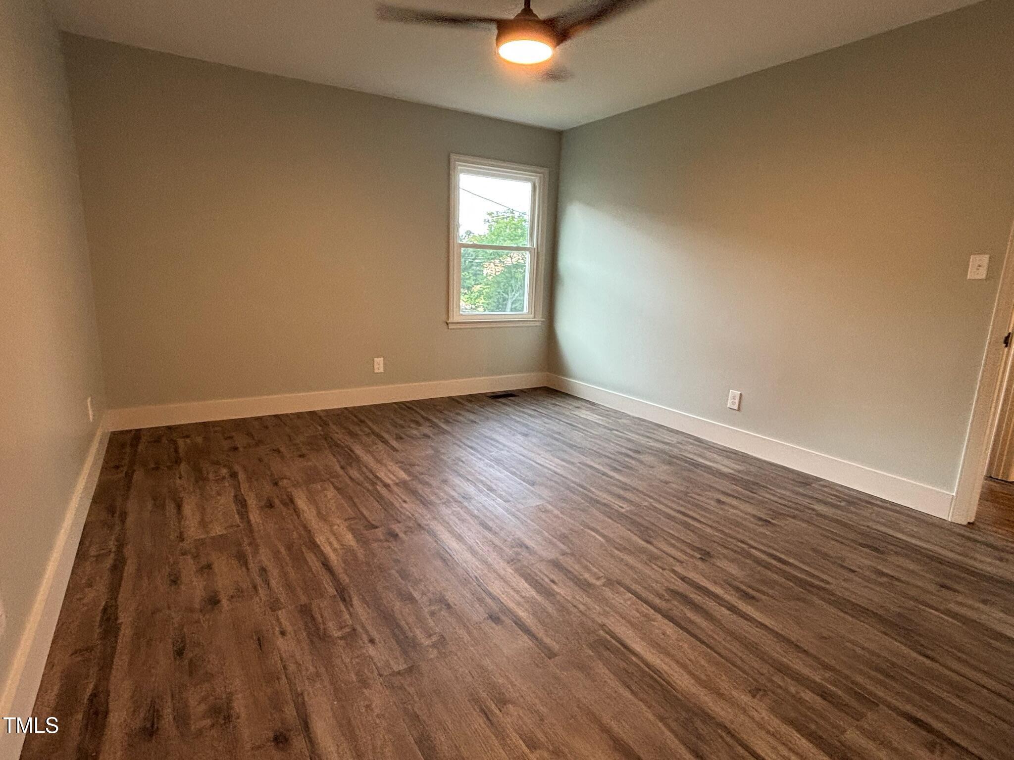 2413 Trawick Road Raleigh, NC 27604 - Photo 19 of 43 an empty room with wooden floor and windows