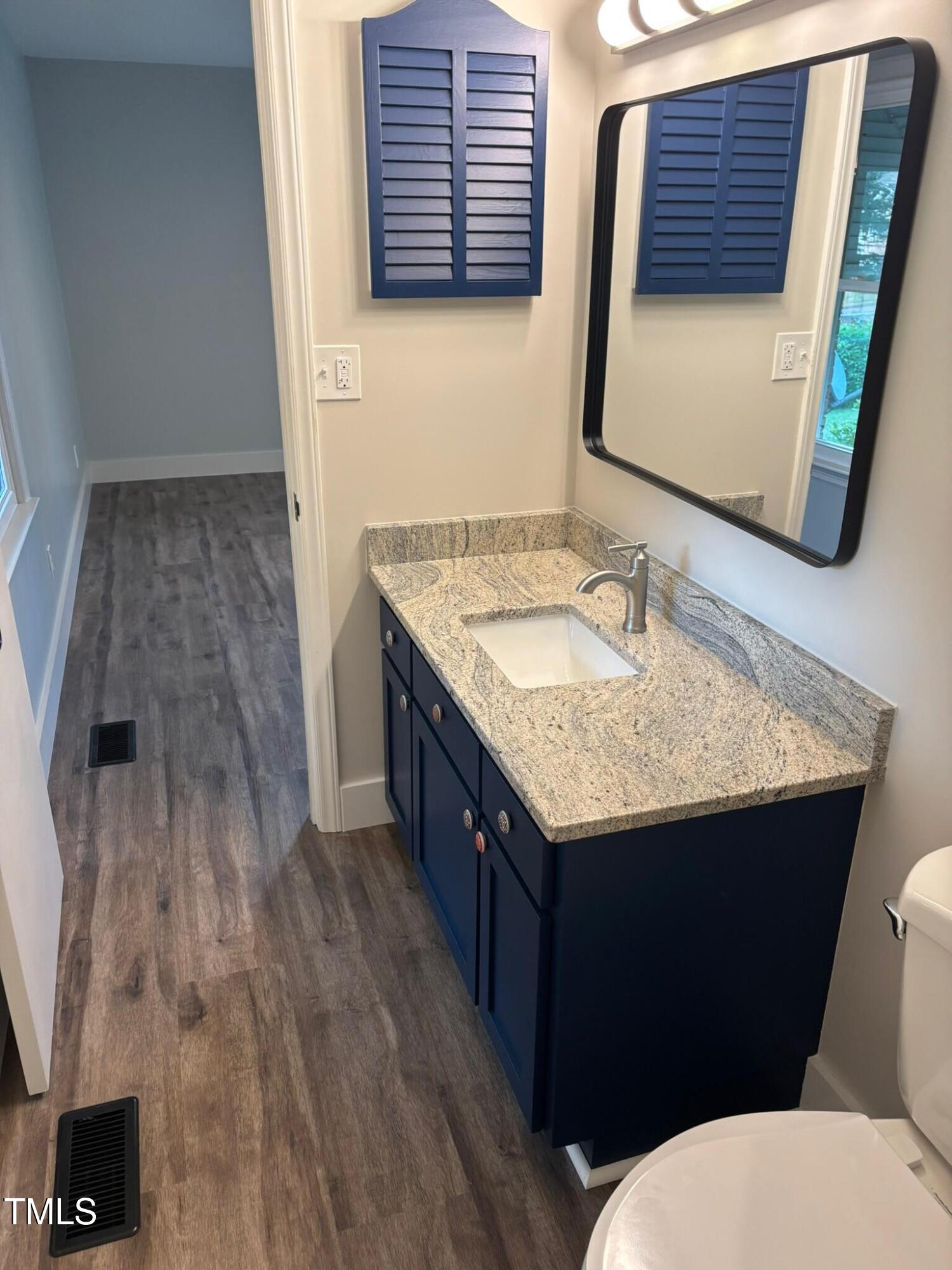2413 Trawick Road Raleigh, NC 27604 - Photo 22 of 43 a bathroom with a granite countertop sink and a mirror