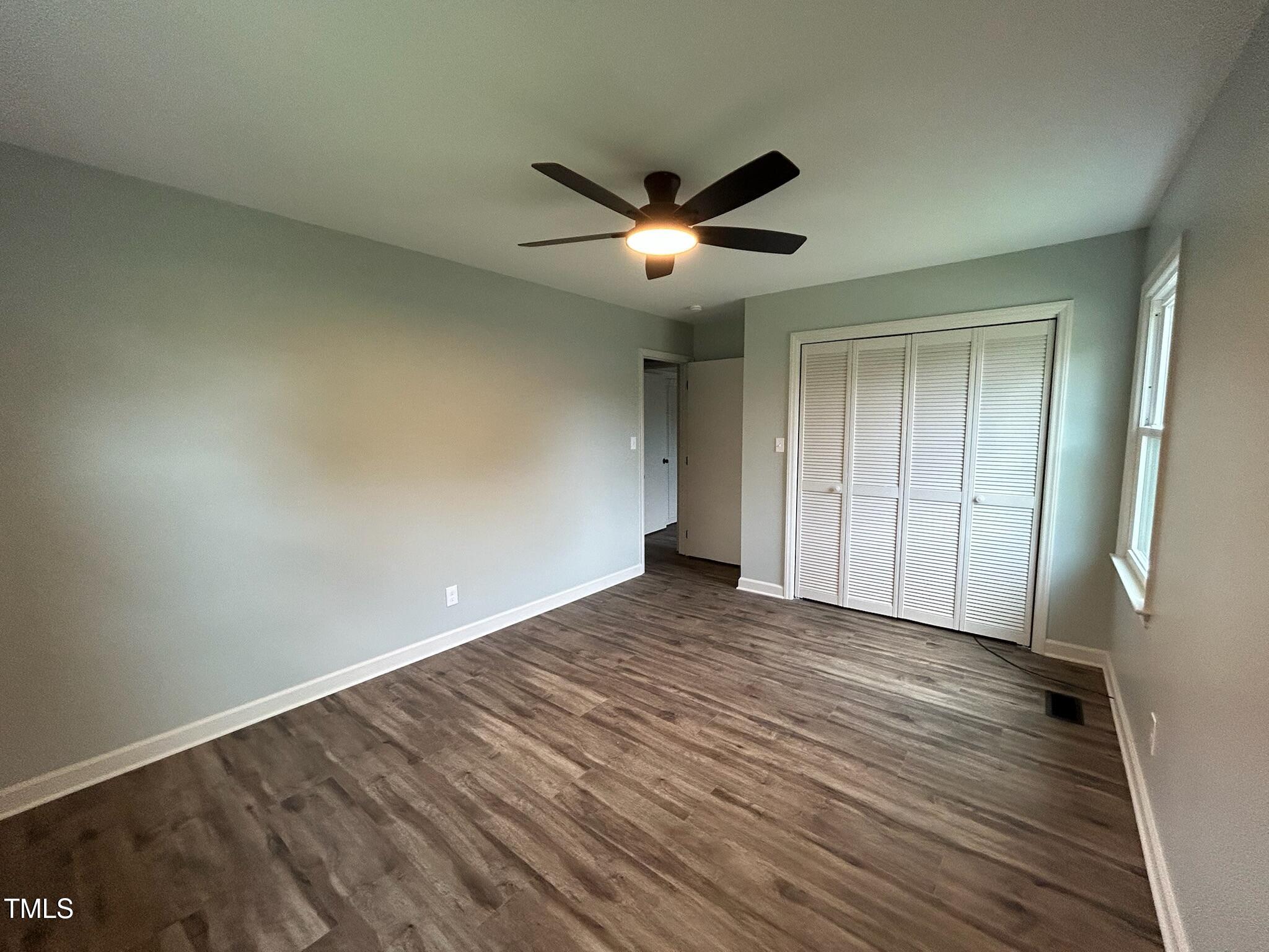 2413 Trawick Road Raleigh, NC 27604 - Photo 26 of 43 a view of an empty room with wooden floor and a ceiling fan