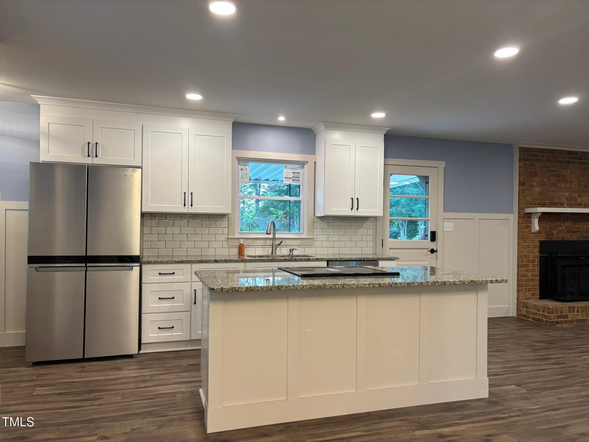 2413 Trawick Road Raleigh, NC 27604 - Photo 6 of 43 a kitchen with stainless steel appliances granite countertop a refrigerator a sink a stove a microwave and white cabinets with wooden floor