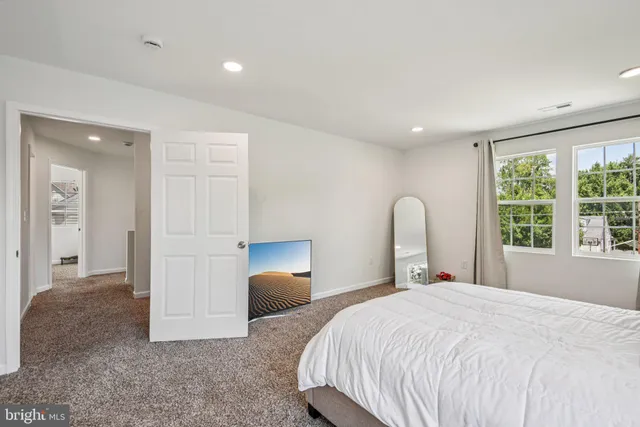 a bedroom with a bed and a large window