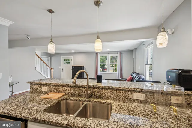 a kitchen with a sink granite counter tops and a wooden floor