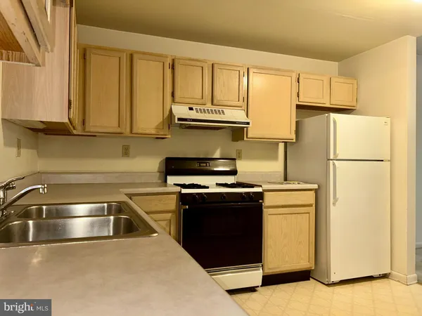 a kitchen with appliances a sink and cabinets