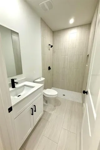 a bathroom with a double vanity sink toilet and shower