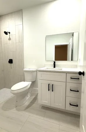a bathroom with a sink a toilet and shower