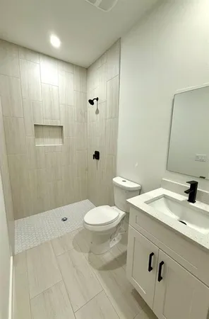 a bathroom with a sink a toilet and shower