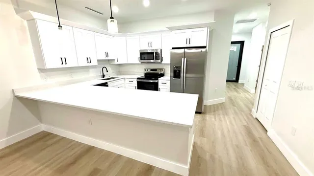 a kitchen with stainless steel appliances a refrigerator sink and microwave