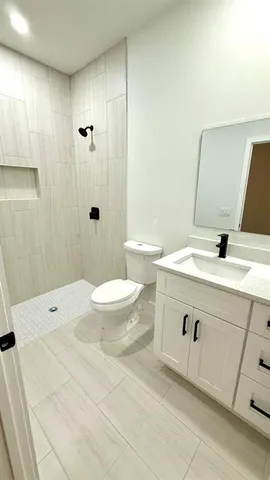 a bathroom with a sink a toilet and shower