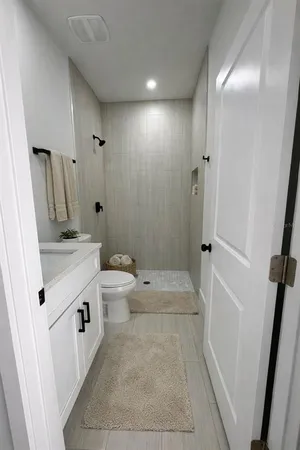 a bathroom with a sink a toilet and shower