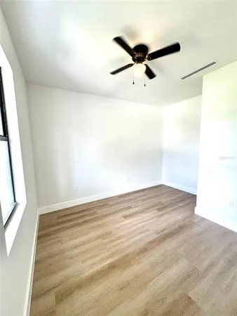 a view of a big room with wooden floor and windows
