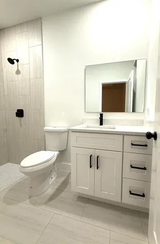 a bathroom with a sink a toilet and shower