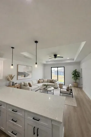 a large white kitchen with a large window stainless steel appliances and cabinets