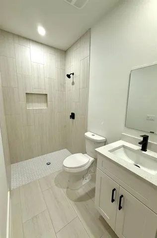 a bathroom with a sink a toilet and shower