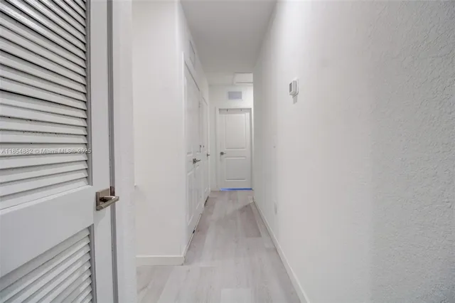 a view of a hallway with wooden floor