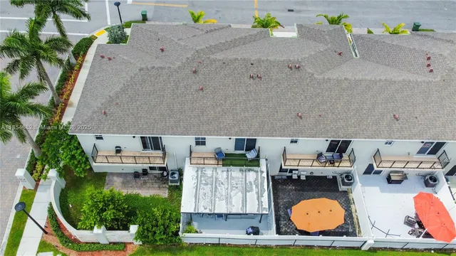 an aerial view of residential houses with outdoor space and swimming pool