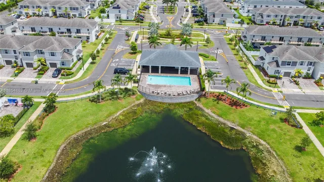 an aerial view of residential houses with outdoor space and swimming pool