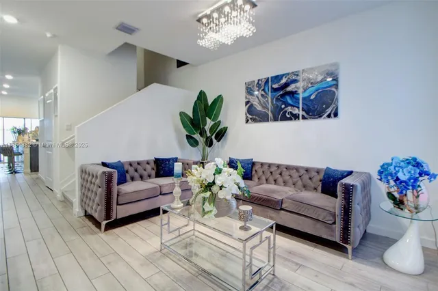a living room with furniture and a chandelier