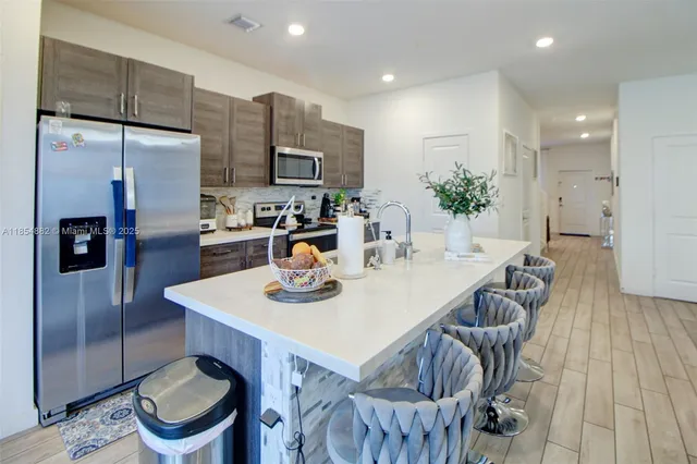 a kitchen with a table chairs and a refrigerator