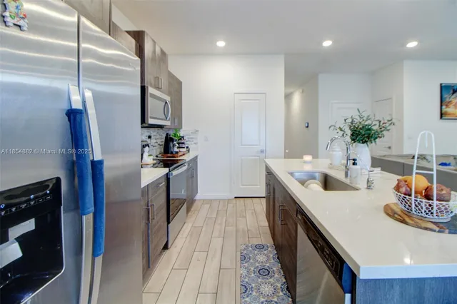 a kitchen with sink refrigerator and microwave